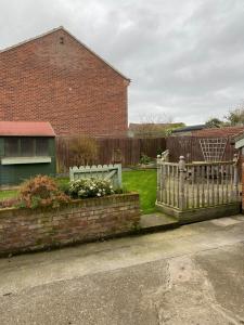 une clôture blanche dans une cour à côté d'une maison dans l'établissement Ivy House, three bed cottage, parking garden, à Skipsea