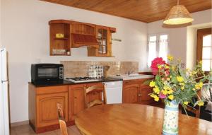 une cuisine avec des placards en bois et une table avec un vase de fleurs dans l'établissement Nice Home In St, Julien De Peyrolas With Kitchen, à Aiguèze