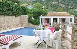 a patio with a table and chairs next to a pool at Awesome Home In El Gastor With 2 Bedrooms, Wifi And Outdoor Swimming Pool in El Gastor