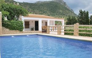 a villa with a swimming pool in front of a house at Awesome Home In El Gastor With 2 Bedrooms, Wifi And Outdoor Swimming Pool in El Gastor