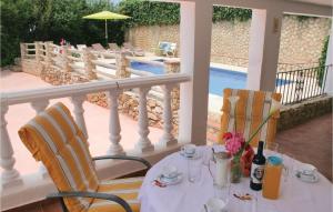 a table and chairs on a balcony with a pool at Awesome Home In El Gastor With 2 Bedrooms, Wifi And Outdoor Swimming Pool in El Gastor