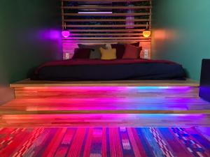 a bedroom with a bed with pink and purple lights at Nocturnal Spa Package Midnight to Noon in Coubron