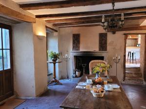 ein Wohnzimmer mit einem Tisch und einem Kamin in der Unterkunft La Cressonnière in Parthenay