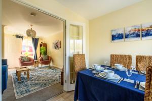 a dining room with a blue table and chairs at Charming & Spacious 3BR With Private Parking Near Ipswich in Ipswich