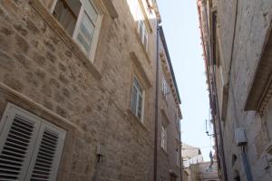 un callejón en un antiguo edificio de piedra con ventanas en Apartment La Petite, en Dubrovnik