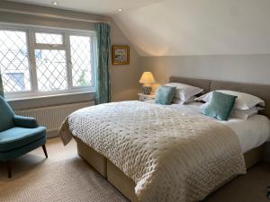 a bedroom with a large bed and a blue chair at East Park Lodge in Cowes