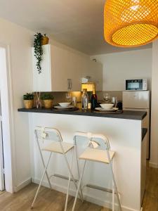 a kitchen with two bar stools and a counter top at Chez Jade - Spa, Gare et centre ville in Rennes