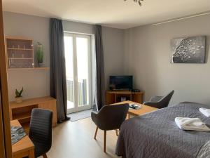 ein Schlafzimmer mit einem Bett und einem Tisch und Stühlen in der Unterkunft Einraumapartment mit Seeblickbalkon in Rheinsberg + 9 Fotos