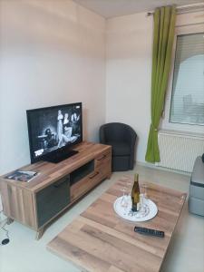 a living room with a television and a table with a bottle of wine at Grand'Roche in Cornimont