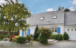 a white house with blue doors and a tree at Holiday Home Penestin Chemin De Camaret in Pénestin