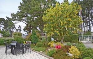 a patio with a table and chairs in a garden at Holiday Home Penestin Chemin De Camaret in Pénestin