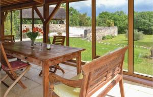 a wooden table with a vase of flowers on a patio at Cozy Home In Padiracbascoul With Wifi in Padirac