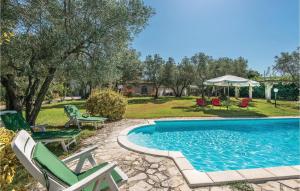 uma piscina com cadeiras e um quintal com árvores em Villa Laura em Monteleone Sabino