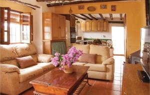 ZagrillaにあるAmazing Home In Zagrilla, Crdoba With Kitchenのリビングルーム(ソファ、花のテーブル付)