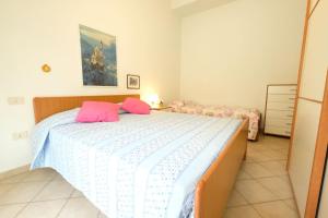 Un dormitorio con una cama con almohadas rosas. en Armonia Pineto Vacanza, en Pineto