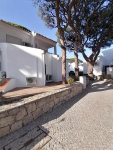 una casa con árboles y una pared de piedra en Villa 88, en Almancil