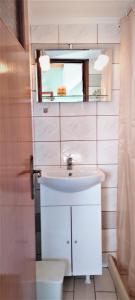 La salle de bains est pourvue d'un lavabo blanc et d'un miroir. dans l'établissement AGNANTIO, à Monemvasia