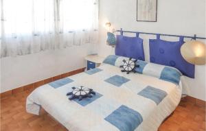 a bedroom with a blue and white bed and a window at Stunning Apartment In Carnon Plage With 2 Bedrooms in Carnon-Plage