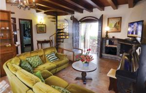 a living room with a yellow couch and a fireplace at Amazing Home In Palafolls With Wifi, Private Swimming Pool And Outdoor Swimming Pool in Mas Carbo