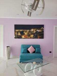una sala de estar con un sofá azul y una pintura en Mare Azzurro en Marina di Camerota