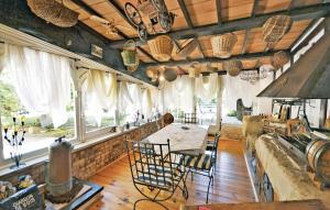 eine Küche mit einem Tisch, Stühlen und Fenstern in der Unterkunft Amazing Home In Velleron With Outdoor Swimming Pool in Velleron