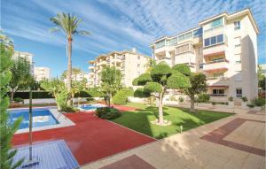 un complexe d'appartements avec une cour dotée d'une piscine et de palmiers dans l'établissement Awesome Apartment In Alfaz Del P With Kitchen, à L'Alfàs del Pi