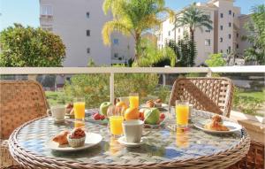 a table with breakfast food and orange juice on a balcony at Lovely Apartment In Alfaz Del Pí in L’Alfàs del Pi