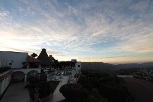 a view of a town at sunset from a building at Hotel Montetaxco in Taxco de Alarcón
