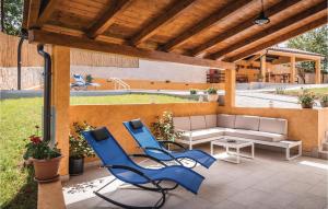 two blue chairs and a couch on a patio at Cozy Home In Barban With Wifi in Barban