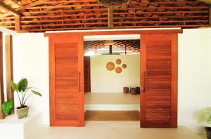 uma porta de madeira aberta num quarto com um corredor em ALTO BONITO em Atins