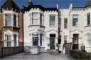 een groot wit huis met een voortuin bij Fabulous East Finchley in Londen