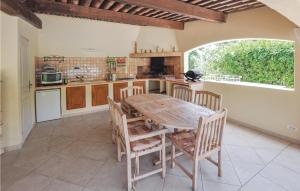 a kitchen with a wooden table and chairs and a counter at 4 Bedroom Cozy Home In Montauroux in Montauroux