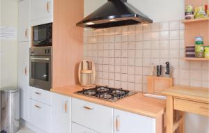 a kitchen with white cabinets and a stove top oven at Amazing Home In St Clément Rancoudray in Mortain