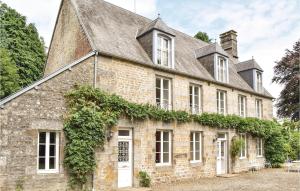 an old stone house with ivy growing on it at Gorgeous Home In St Clment Rancoudray With Kitchen in Mortain