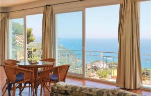 a living room with a table and chairs and large windows at Nice Home In Blanes With Wifi in Blanes