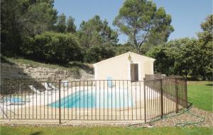 ein kleines weißes Gebäude mit einem Pool hinter einem Zaun in der Unterkunft Nice Home In Bollne With 2 Bedrooms, Wifi And Outdoor Swimming Pool in Bollène