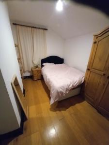 a small bedroom with a bed and a wooden floor at Alistair lodge in Chatham