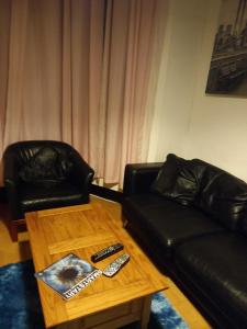 a living room with a leather couch and a coffee table at Alistair lodge in Chatham