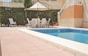 uma piscina com cadeiras, uma mesa e um guarda-sol em Cozy Home In Castalla With Swimming Pool em Castalla