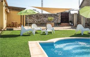 una piscina con sedie e ombrelloni in un cortile di Stunning Home In Villanueva Del Duque a Villanueva del Duque