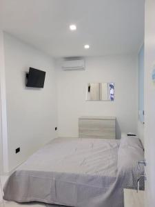 um quarto branco com uma cama e um espelho em Mare Azzurro em Marina di Camerota