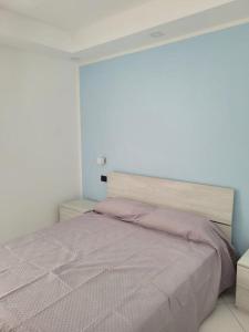 um quarto com uma cama com um edredão roxo em Mare Azzurro em Marina di Camerota
