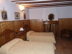 2 camas en una habitación con paredes de madera en CASA RURAL QUIJOTE Y SANCHO en Argamasilla de Alba