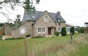 a large stone house with a fence in the yard at Nice Home In Quemper Guznnec With 3 Bedrooms in Quemper-Guézennec