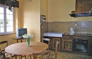 a kitchen with a table with a vase of flowers on it at 3 Bedroom Nice Home In Quemper Guznnec in Quemper-Guézennec