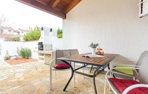 a patio with a table and chairs and a fireplace at Stunning Home In Barbariga With Wifi in Barbariga