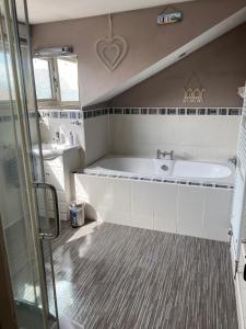 ein Badezimmer mit einer Badewanne und einem Waschbecken in der Unterkunft Ivy House, three bed cottage, parking garden in Skipsea