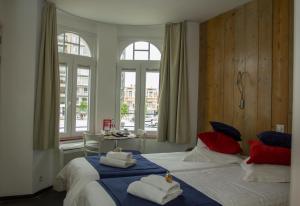 a bedroom with two beds with towels on them at Hotel Aan Zee in De Panne