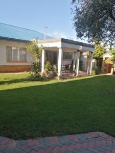 a house with a lawn in front of it at LALA POA GUEST HOUSE in Klerksdorp