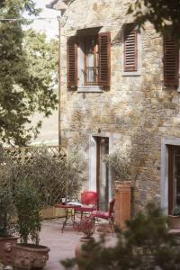 a stone house with a table and chairs in front of it at La Bugia del Sensale in San Donato in Poggio